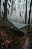 Wildnis Überleben. Bushcraft Zelt unter das Plane im schwer Regen, Umarmen das Ausruhen von Dämmerung. ein Szene von Ausdauer und Elastizität foto