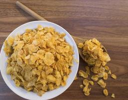 Cornflakes und Schüssel auf Holztisch foto