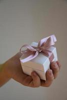 ein Geschenk im ein Weiß Box mit ein Rosa Bogen foto
