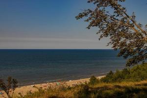 Aussicht von das Böschung zu das Strand auf das baltisch Meer auf ein Sommer- Tag mit Menschen foto