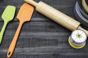 Bäckerei und Kochutensilien mit Küchenuhr auf einem Holztisch foto