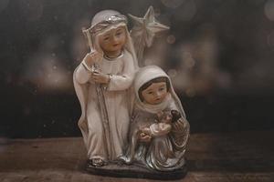 Keramik Figuren von das Mutter von Gott Joseph und Baby Jesus zum das Geburt Szene auf ein dunkel braun Hintergrund foto