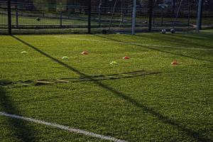 Ausbildung Fußball Tonhöhe mit künstlich Grün Gras und Ausbildung AIDS beleuchtet durch das Nachmittag Sonne foto