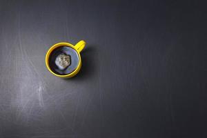 Schwarzer Kaffee mit flachem Rühren im Uhrzeigersinn lag auf zerkratztem schwarzem Hintergrund foto