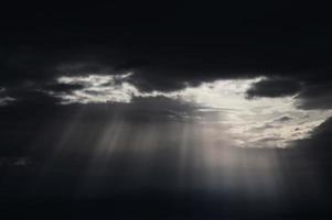 Crepuscular Strahlen durch dunklen bewölkten Himmel foto