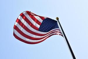 Flagge von Amerika, die auf einer Stange winkt foto