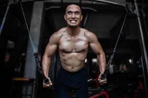 Porträt von asiatisch Mann groß Muskel beim das Fitnessstudio, Thailand Leute, trainieren zum gut gesunder Körper Gewicht Ausbildung, Fitness beim das Fitnessstudio Konzept, Streich zu Bauch Muskeln foto