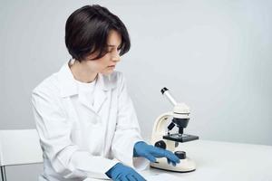 heiter weiblich Labor Assistent im Weiß Mantel Mikroskop Fachmann Wissenschaft Experimente foto