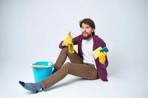 Mann auf das Fußboden mit ein Blau Eimer Hausaufgaben Lebensstil Fachmann foto