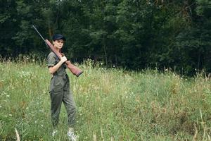 Frau auf draussen Grün Overall schwarz Deckel Waffen foto