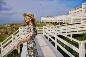 ziemlich Frau im Kleid gehen Luxus Tourismus Sommer- glücklich weiblich entspannend foto