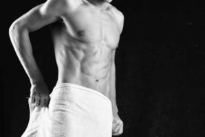 ein Mann mit ein aufgepumpt Körper Abdeckungen selbst mit ein Handtuch Studio Fitness foto