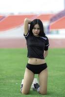 junge schöne asiatische frau trägt fußballspieler jubeln sport, weibliche fans fußball jubelspiel foto
