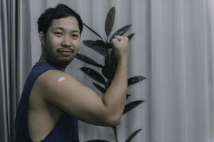 asiatisch gut aussehend Mann zeigen geimpft Arm, bekommen geimpft zu schützen gegen Covid-19, Virenschutz Corona Virus Konzept foto