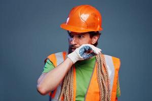 Mann im Orange Farbe Handschuh Fachmann Konstruktion Blau Hintergrund foto