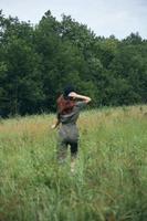 Frau gehen im das Feld Grün Gras frisch Luft foto