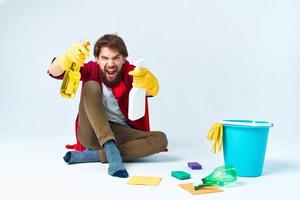 Mann auf das Fußboden Reinigung das Haus mit Reinigung liefert foto