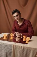 ein Mann mit Orange Orangen auf ein Spiegel drinnen auf ein Hintergrund. foto