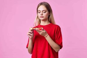 Frau im rot T-Shirt schnell Essen Snack Rosa Hintergrund foto