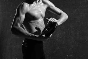 männlich sportlich Körperbau abgeschnitten Aussicht Muskel dunkel Hintergrund foto