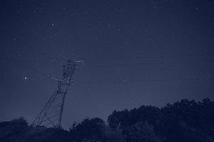 Landschaft mit Elektrizität Pylon gegen sternenklar Nacht Himmel foto