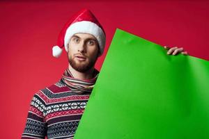 gut aussehend Mann im ein Weihnachten Hut mit Grün Attrappe, Lehrmodell, Simulation Studio posieren foto