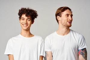 zwei heiter freunde im T-Shirts Stand Seite durch Seite isoliert Hintergrund Freude foto