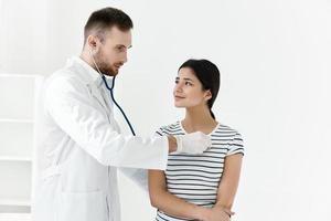Arzt im ein Weiß Mantel Stethoskop Untersuchung von ein geduldig Krankenhaus foto