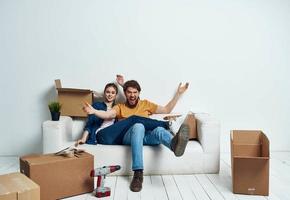 ein Zimmer auf ein Weiß Sofa mit Kisten ziehen um Wohnungen foto