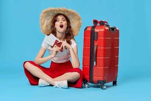 Frau mit rot Koffer Sitzung auf das Fußboden Reisepass und Flugzeug Tickets Lebensstil foto