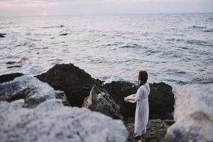 Frau Reisender genießen zum Aussicht von das schön Meer auf ihr Urlaub Freiheit foto