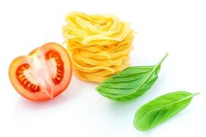 italienisches Nahrungsmittelkonzept der Fettuccine mit Tomate und süßem Basilikum lokalisiert auf einem weißen Hintergrund