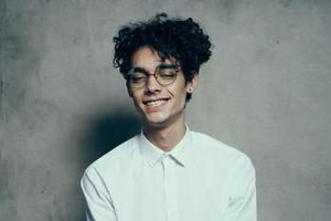 Porträt von ein glücklich Kerl mit Brille lockig Haar Weiß Hemd Fotoshooting Modell- foto