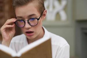 Schüler mit Brille Gehen um das Stadt mit ein Buch Lebensstil foto