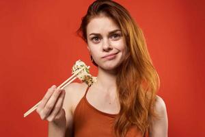 süß rothaarig Frau Essstäbchen Rollen und Meeresfrüchte Snack foto