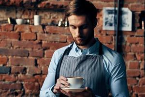 männlich Bedienung Bedienung ein Tasse von Kaffee Bestellung Fachmann foto