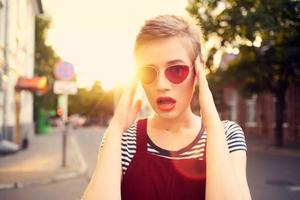 Frau tragen Sonnenbrille draußen gehen posieren Mode foto