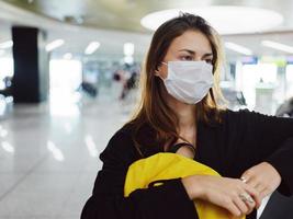 Frau tragen medizinisch Maske Flughafen warten Gepäck Nahansicht foto