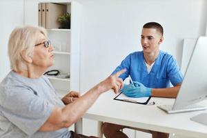 ein Alten Frau reden zu ein Arzt ein Besuch zu das Krankenhaus foto