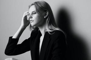 ästhetisch nachdenklich traurig blond jung Modell- posieren im klassisch Jacke berühren Strumpf Haar beim Studio. schön Dame nachdenklich suchen und streicheln ihr Locken. schwarz und Weiß Konzept foto