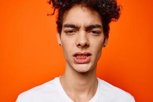 heiter Kerl im ein Weiß T-Shirt Emotion Nahansicht Orange Hintergrund foto