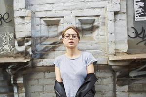 abgeschnitten Aussicht von Frau im Leder Jacke in der Nähe von Gebäude mit Brille foto