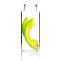 hausgemachte Hautpflege mit Avocado-Scheiben in einer Glasflasche lokalisiert auf einem weißen Hintergrund