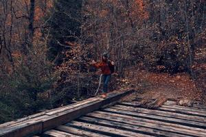 Frau Tourist Kreuze das Brücke Über das Fluss Reise im Herbst foto