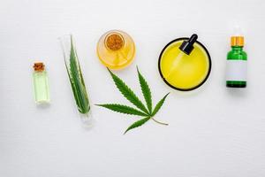 Glasflasche Cannabisöl und Hanfblätter auf weißem Hintergrund foto
