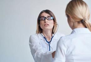 Arzt und geduldig auf Licht Blau Hintergrund Stethoskop Gesundheit Probleme abgeschnitten Aussicht foto