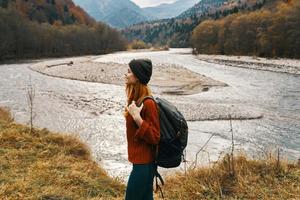 Frau im Herbst im das Berge mit ein Rucksack auf ihr Schultern Reise Tourismus Fluss foto