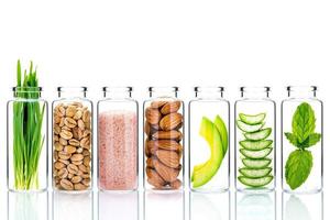 hausgemachte Hautpflege mit natürlichen Zutaten und Kräutern in Glasflaschen lokalisiert auf einem weißen Hintergrund foto