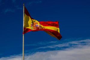 Flagge von Spanien rot Gelb auf Blau Himmel Hintergrund mit Weiß Wolken foto