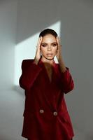 attraktiv Frau halten Gesicht rot Jacke Mode Studio foto